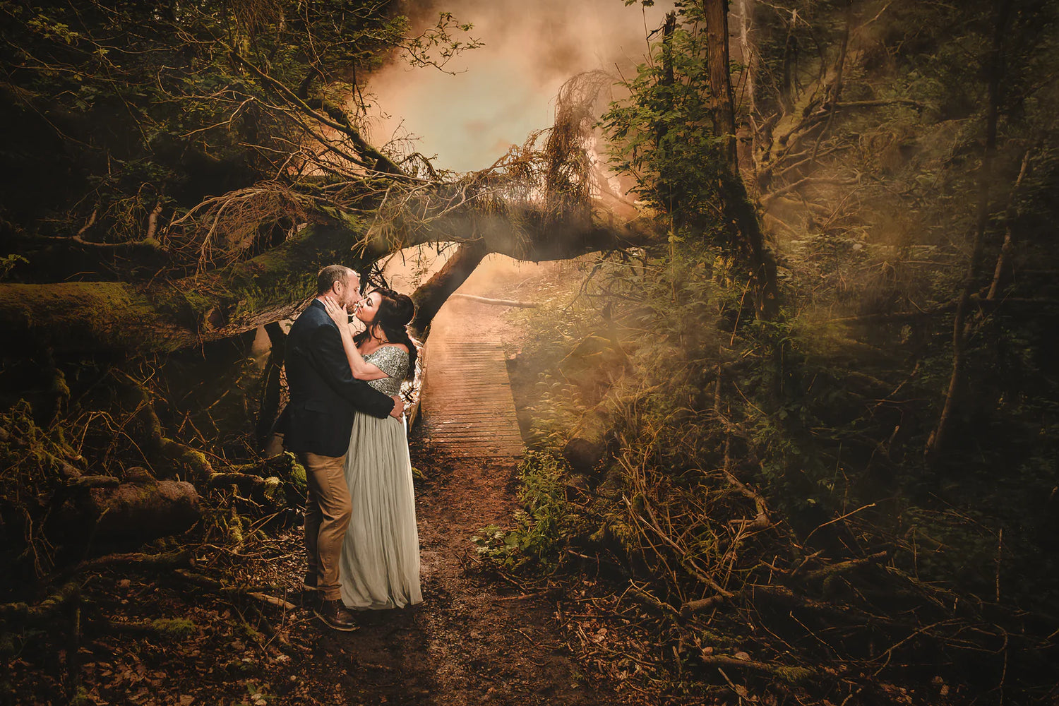 Photo of a couple kissing in a whimsical scene in the woods, taken by photographer Kevin Wyllie
