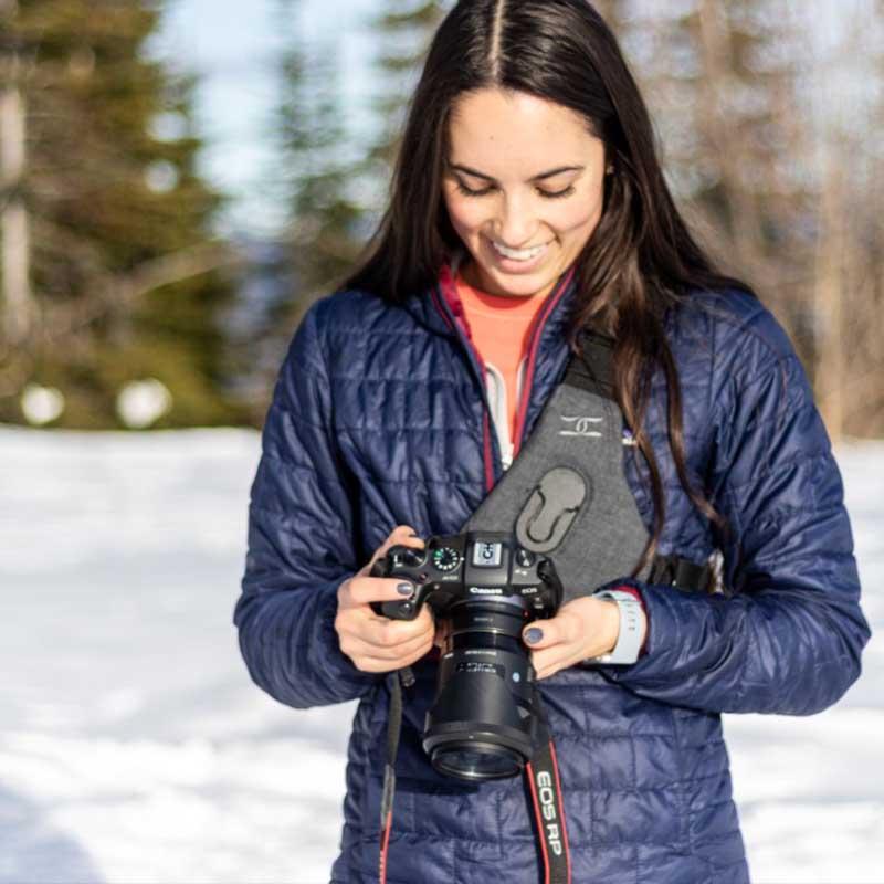 Woman carrying a DSLR camera using the best camera strap