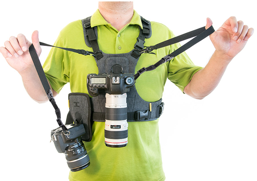 Man demonstrating how to wear a G3 camera harness with two cameras attached to tethers